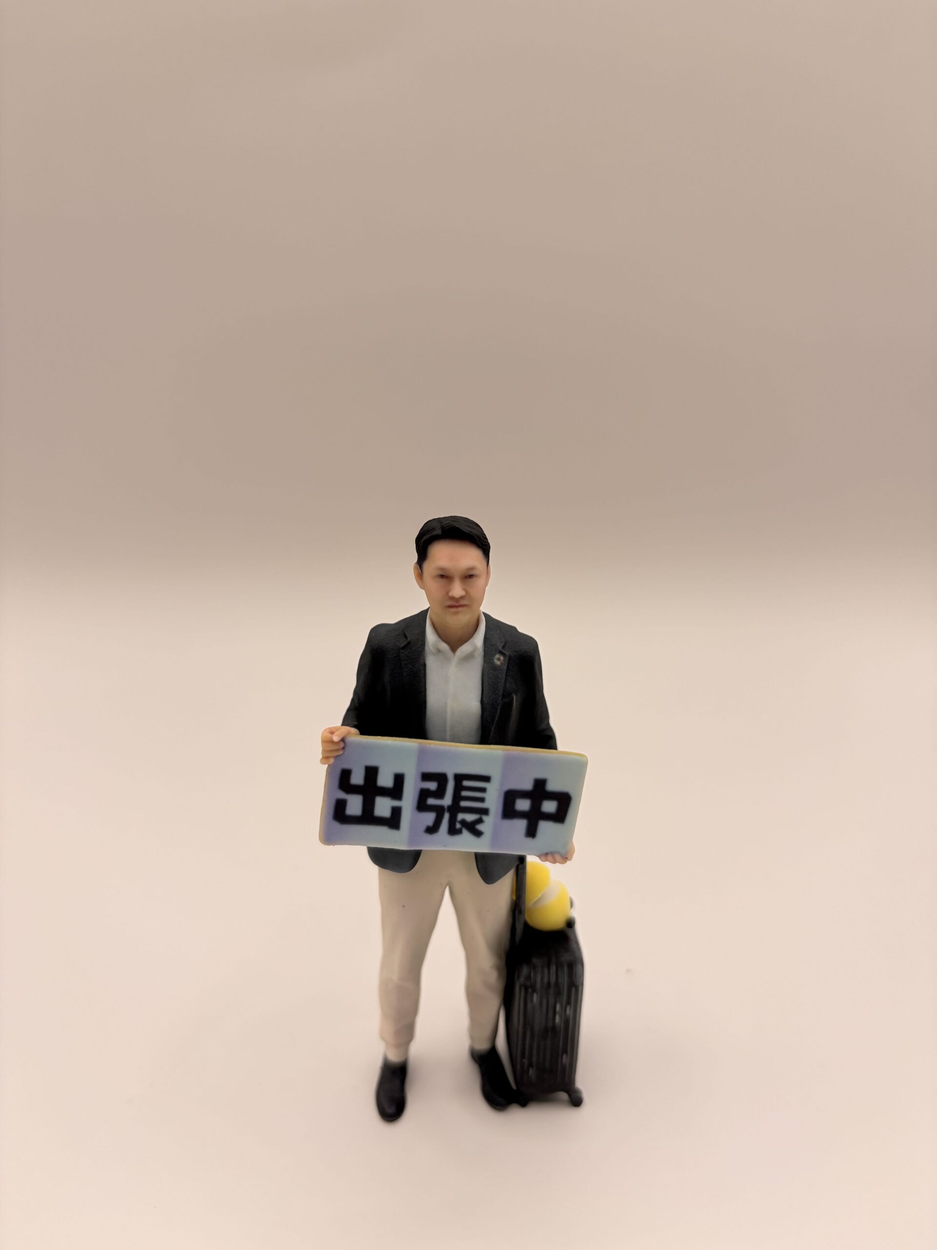 出張中プレートを持ったフィギュア（正面）