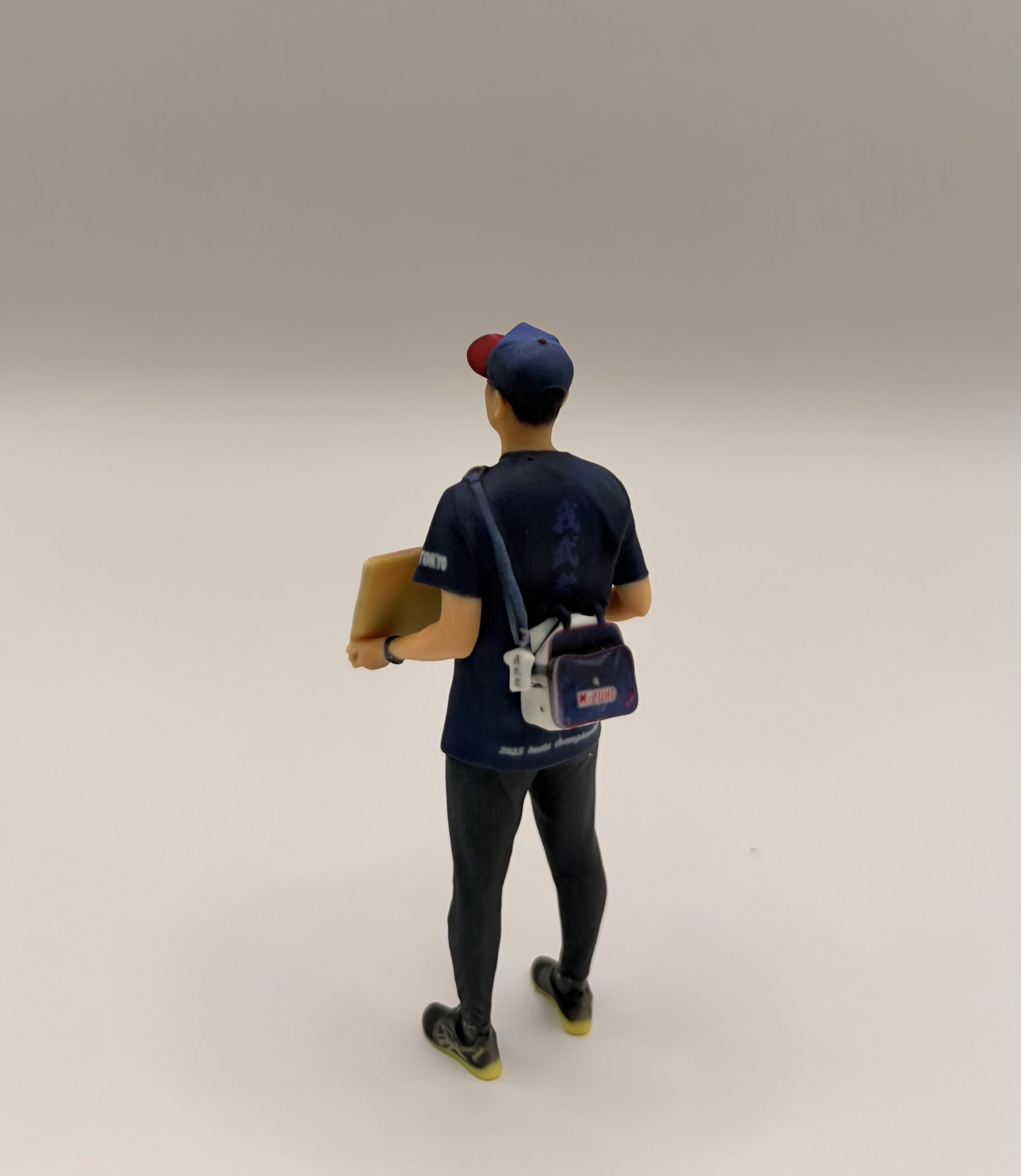 外出中プレートを持ったフィギュアのうしろ姿