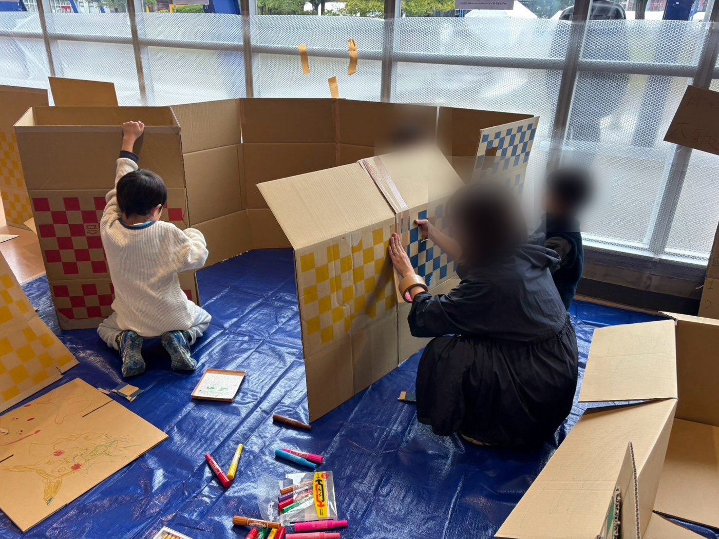 段ボールでおうちを作る子どもたち